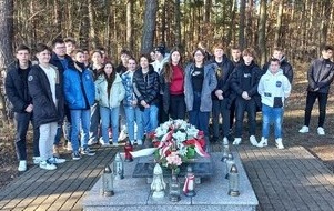 na zdjęciu widać uczni&oacute;w z klasy VIII przy Pomniku Żołnierzy Wyklętych