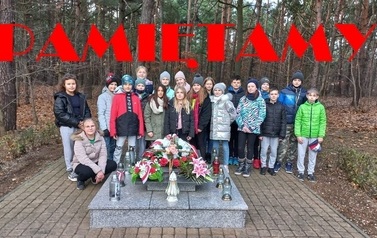 na zdjęciu widać uczni&oacute;w przy pomniku, kt&oacute;ry upamiętnia ofiary powstania wielkopolskiego