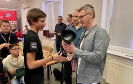 na zdjęciu widać wręczenie pucharu laureatowi zawod&oacute;w szachowych