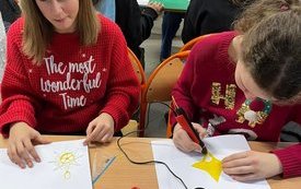 na zdjęciu widać uczennice wykonujące dekoracje na choinkę za pomocą długopisu 3D
