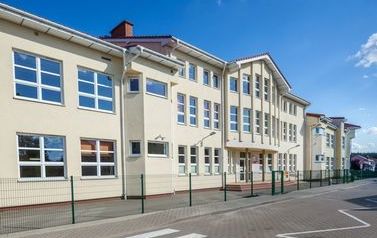 Zdjęcie przedstawia budynek szkolny z gł&oacute;wnym wejściem