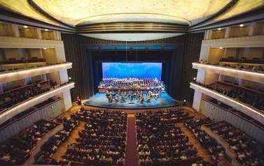 wnętrze z lotu ptaka Filharmonii Szczecińskiej i widok na orkiestrę i śpiewające ch&oacute;ry dziecięce z r&oacute;żnych szk&oacute;ł
