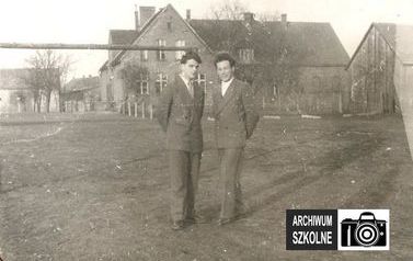 Zdjęcie przedstawia nauczycieli szkoły w Łochowie w roku 1958. W tle jedyny w&oacute;wczas budynek szkolny, dziś budynek B.