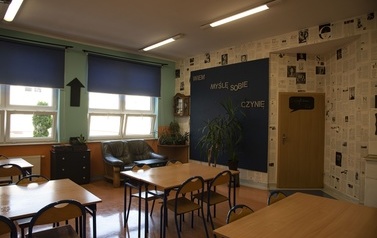 Na zdjęciu widać fragment sali od języka polskiego z oryginalnie ozdobioną ścianą gazetami i sk&oacute;rzaną kanapą do wypoczynku