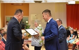 na zdjęciu widać przewodniczącego rady rodzic&oacute;w, kt&oacute;ry wręcza list gratulacyjny dyrektorowi szkoły
