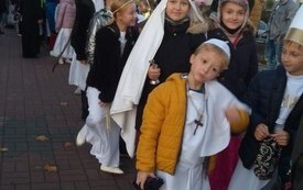 na zdjęciu widać uczni&oacute;w idących w pochodzie wszystkich świętych