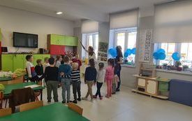 na zdjęciu widać bawiące się dzieci w kręgu wraz z logopedą