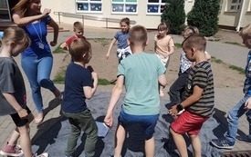 na zdjęciu widać nauczyciela logopedii z uczniami podczas zabaw logopedycznych