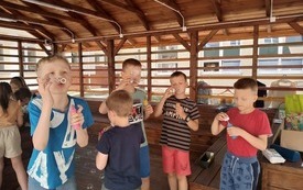 na zdjęciu widać dzieci dmuchające bańki podczas zabaw logopedycznych