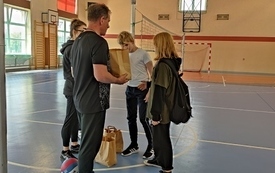 na zdjęciu widać nauczycieli wf-u wręczających nagrody w zawodach sportowych