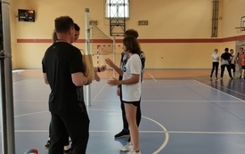 na zdjęciu widać nauczycieli wf-u wręczających nagrody w zawodach sportowych