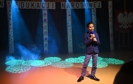 na zdjęciu widać śpiewającego ucznia w blasku kolorowych reflektor&oacute;w