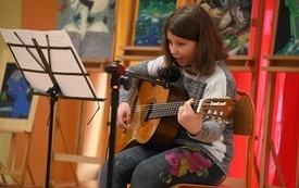 na zdjęciu widać uczestniczkę Szkolnego Mam Talent podczas gry na gitarze
