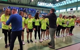 na zdjęciu widać uczennice w ż&oacute;łtych koszulkach sportowych, kt&oacute;rym wręczane są medale