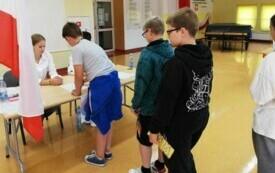 na zdjęciu widać uczni&oacute;w biorących udział w wyborach do samorządu szkolnego