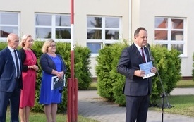 Na zdjęciu widać przemawiającego dyrektora szkoły, w tle  stojące Panie wicedyrektorki i radnego gminy
