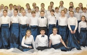 ch&oacute;r dziecięcy szkolny Sereno z 2014 roku w odświętnych strojach (białe koszule i niebieskie sp&oacute;dnice)