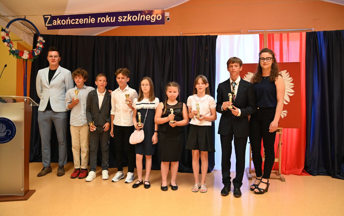 Zakończenie 2022 Na zdjęciu widać uczniów z pucharami za wynik sportowe oraz dwóch nauczycieli wychowania fizycznego.