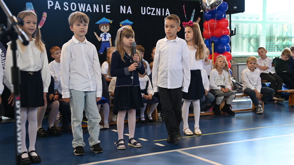 Zdjęcie przedstawia uczni&oacute;w klas 1 na&nbsp;środku sali gimnastycznej, kt&oacute;rzy zostali wytypowani do prowadzenia ceremonii pasowania na&nbsp;pierwszoklasistę.
