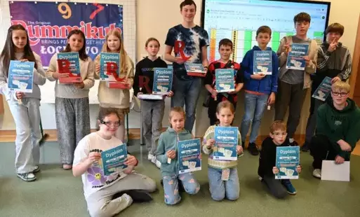 Na zdjęciu widać uczniów, którzy uczestniczyli w rozgrywkach Szkolnego Turnieju Rummikub, pozujących z dyplomami i statuetkami.