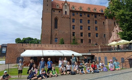 Zdjęcie przedstawia uczniów klasy 3b na wycieczce, w tle zamek w miejscowości Gniew.