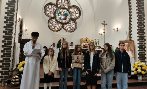 Na zdjęciu widać uczniów na tle ołtarza kościoła.